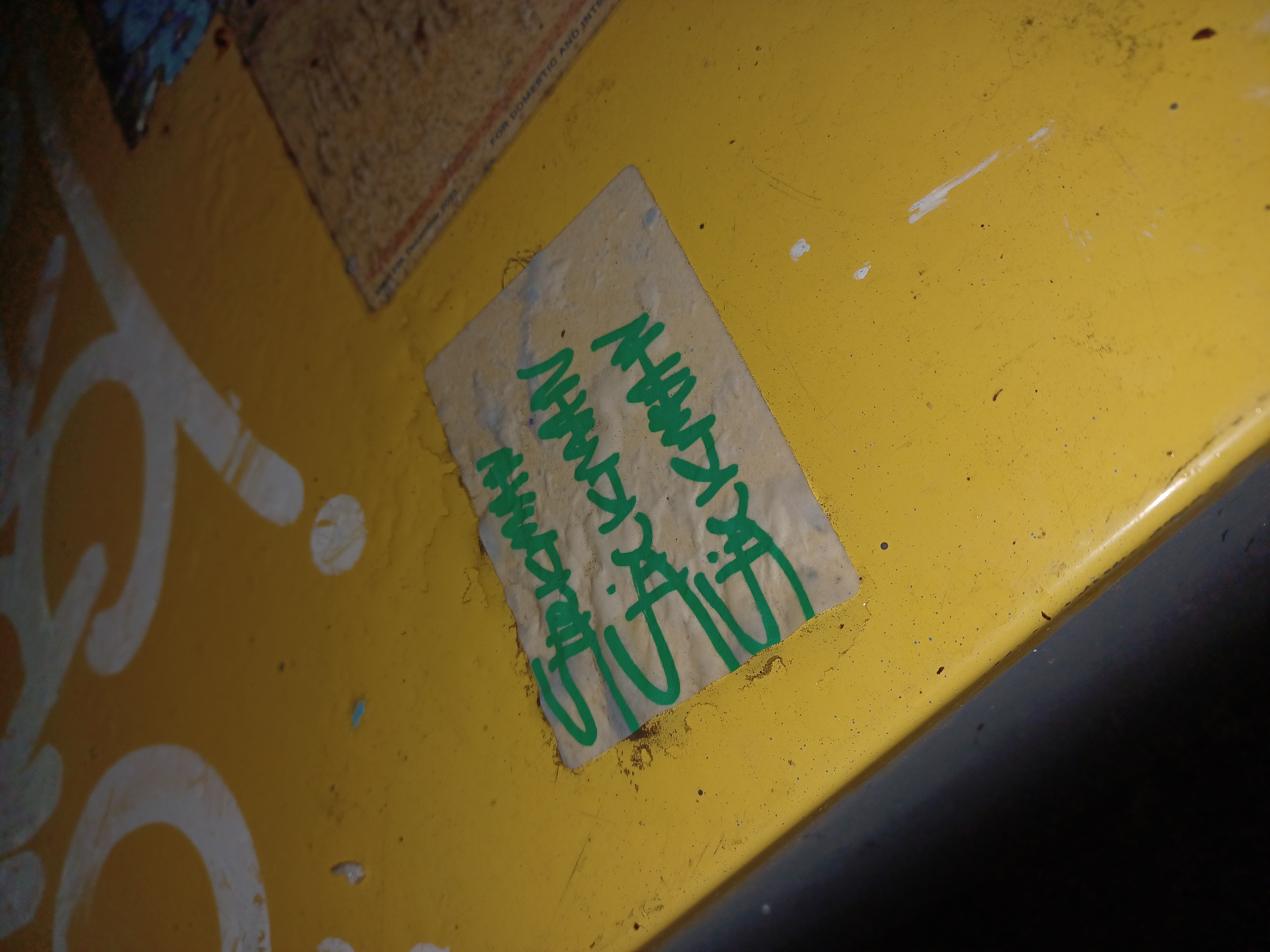 a newspaper box with the word stickman written on it three times photographed at night with a flash